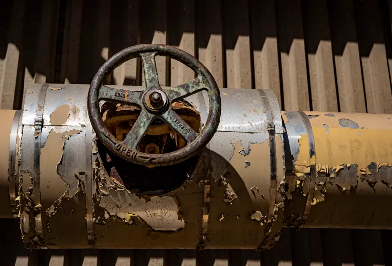 Close-up of a corroded industrial valve on a pipeline